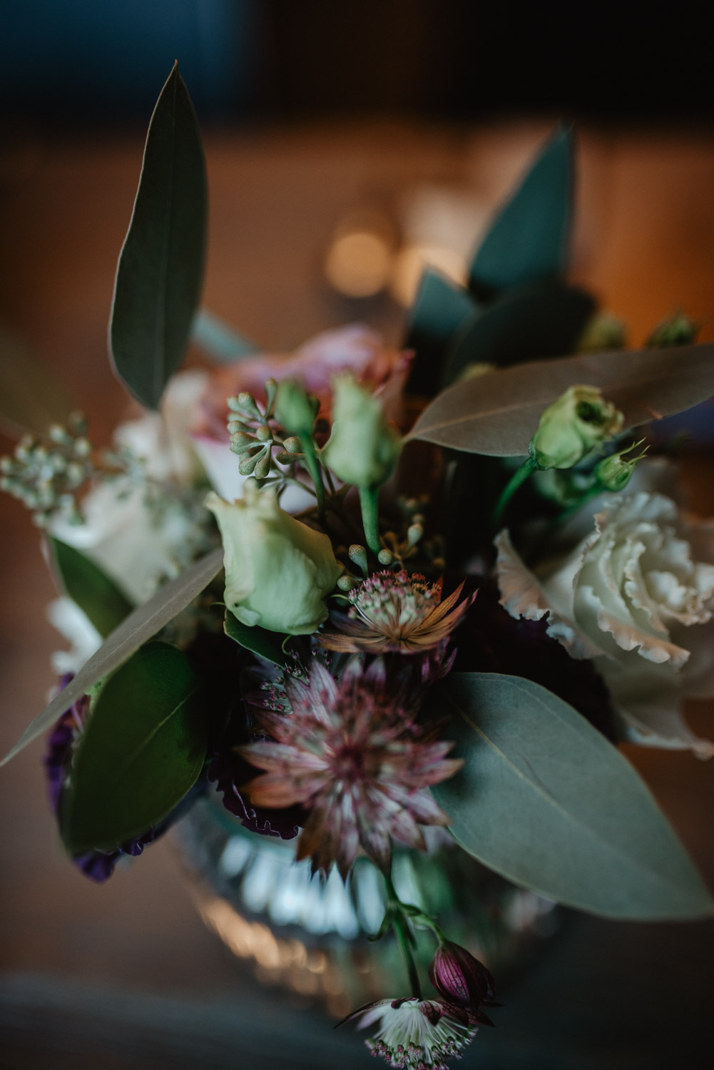 Blumenarrangement in Glasvase mit Rosen und Eukalyptus.