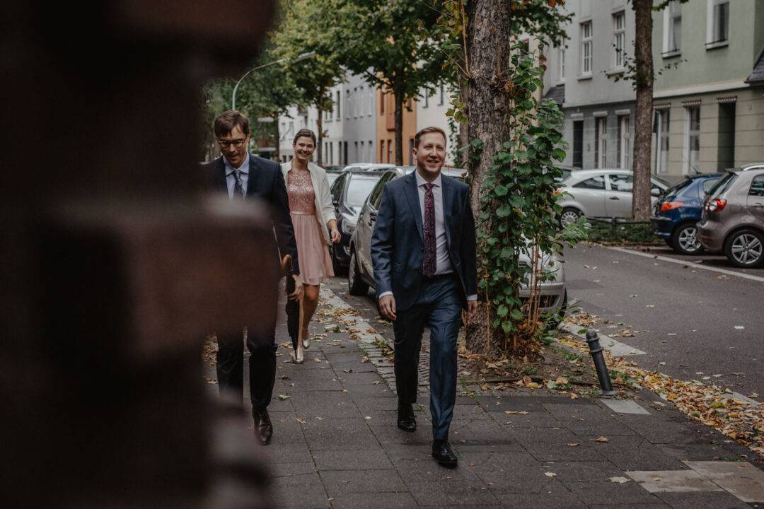 Hochzeitsgäste spazieren zur Trauung in Köln