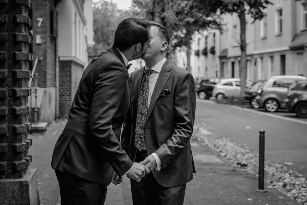 Kuss zwischen Bräutigamen bei gleichgeschlechtlicher Hochzeit in Köln