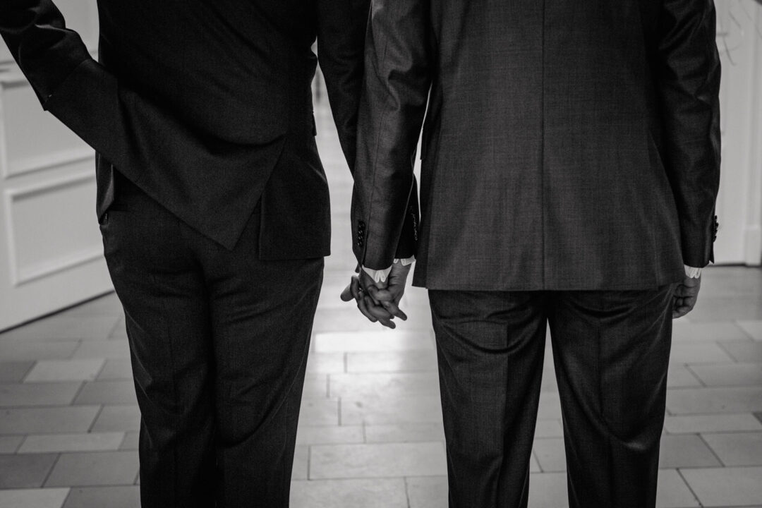 Zwei Bräutigame Hand in Hand beim Einzug zur Hochzeit