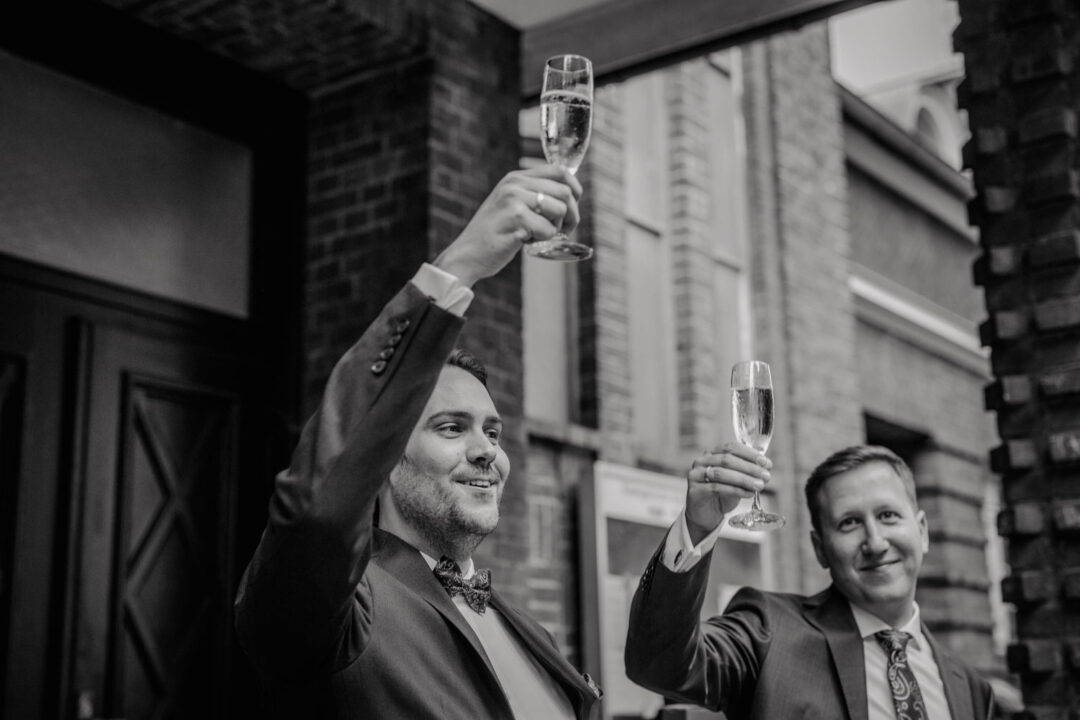 Bräutigame stoßen mit Sekt auf ihre Hochzeit an