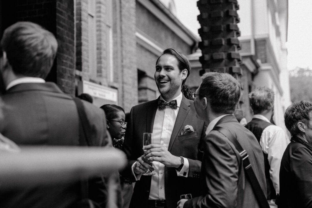 Hochzeitsgast lacht beim Sektempfang in Köln