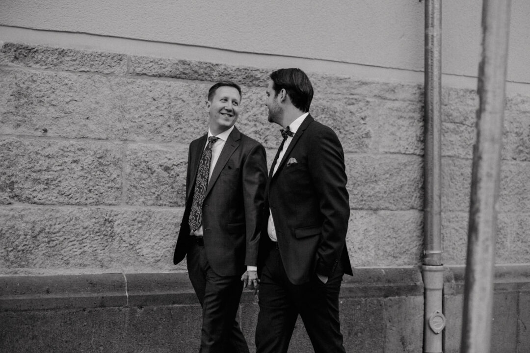 Bräutigame blicken sich lächelnd an beim Spaziergang