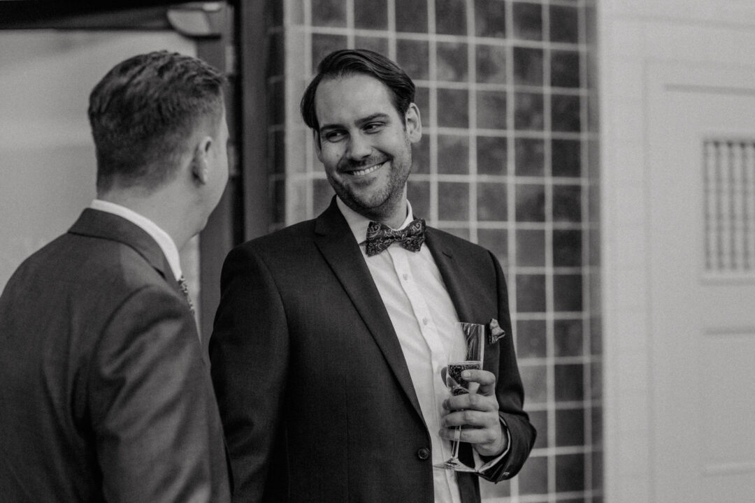 Bräutigam mit Sektglas blickt verliebt zum Partner