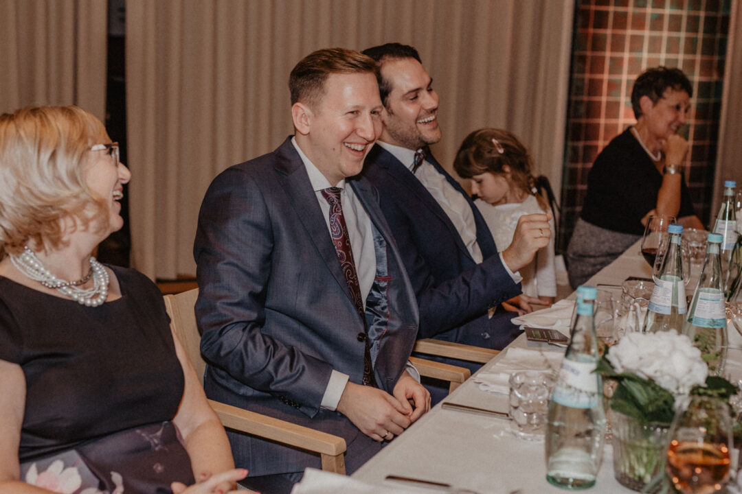 Bräutigame lachen bei Hochzeitsdinner in Köln