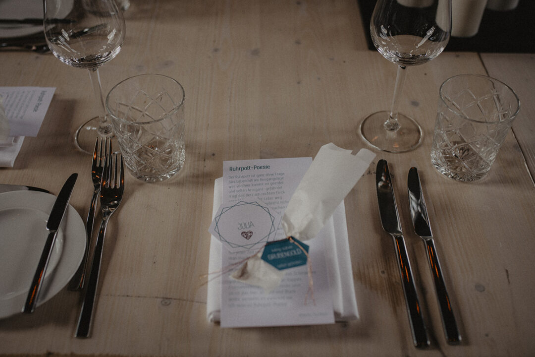 Minimalistische Hochzeitstafel mit Menükarten und Gläsern