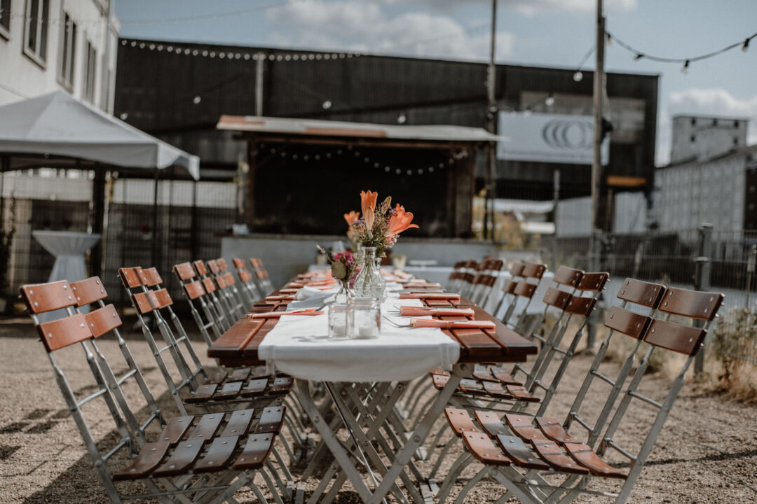 Hochzeitstafel mit Blumen vor Industrie-Kulisse
