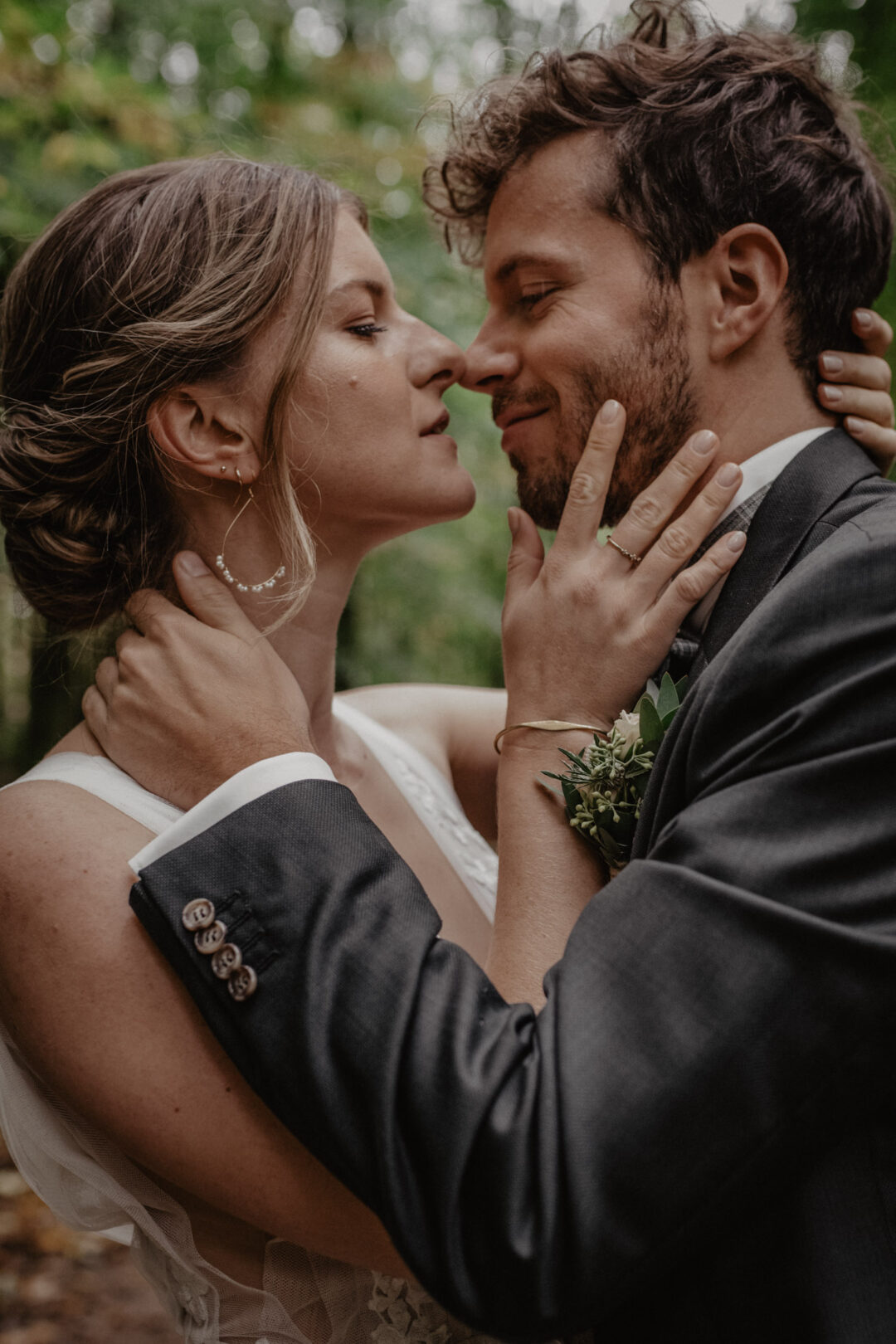 Brautpaar küsst sich innig im Wald