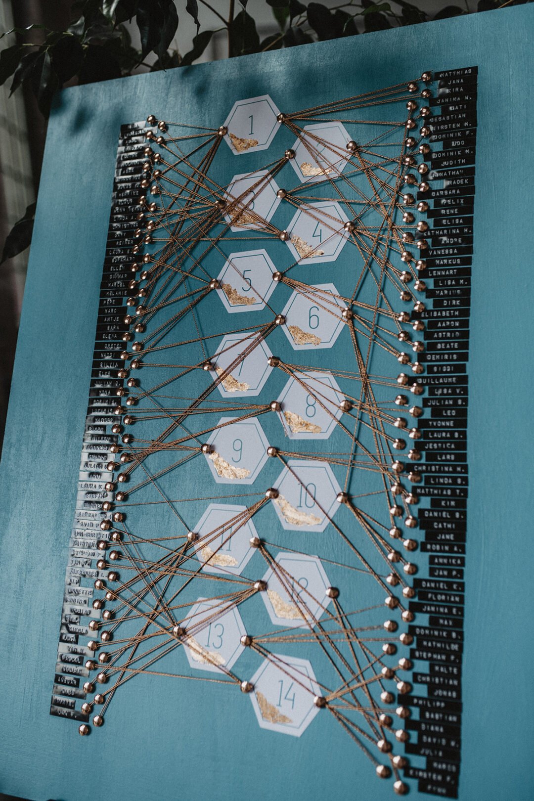 Kreativer Sitzplan auf Holzplatte mit Fäden verbunden