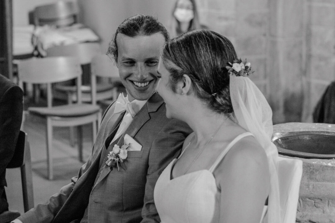 Brautpaar lächelt sich während Trauung in Kirche an