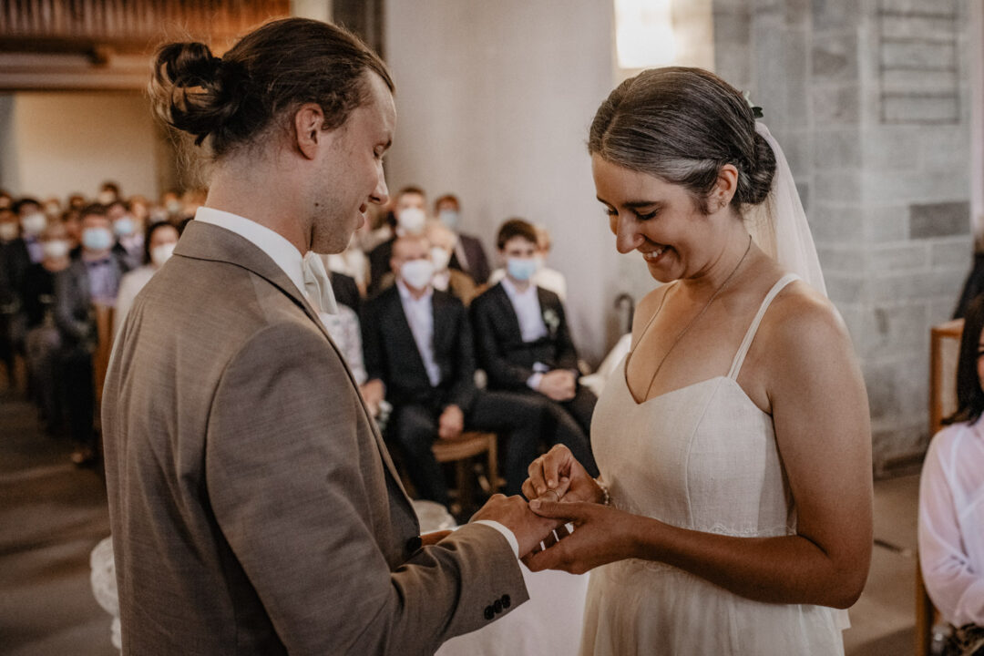 Braut steckt Bräutigam den Ring an in Kirche Hennen