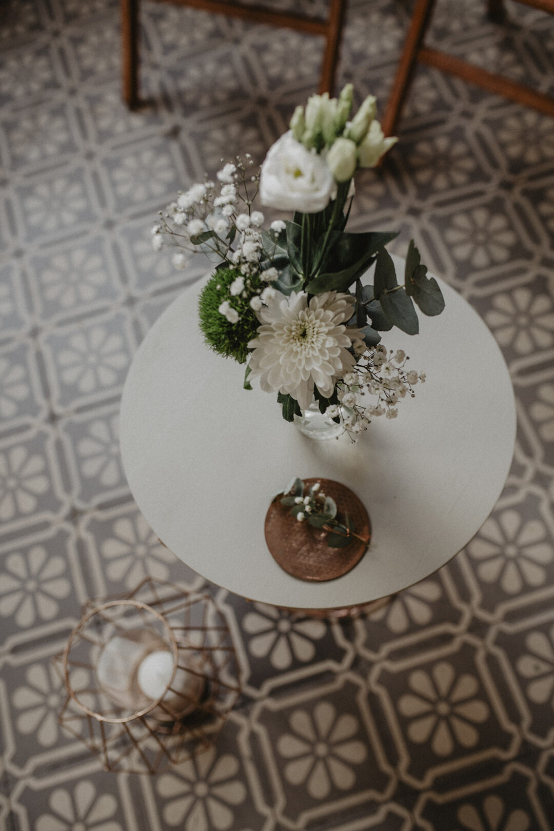 Nahaufnahme eines kleinen runden Tisches mit Blumenarrangement und Kerze im Gasthaus Stromberg.