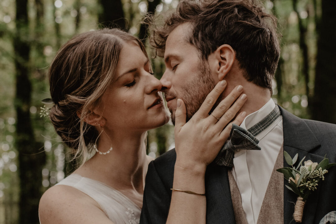 Brautpaar küsst sich bei freier Trauung im Wald