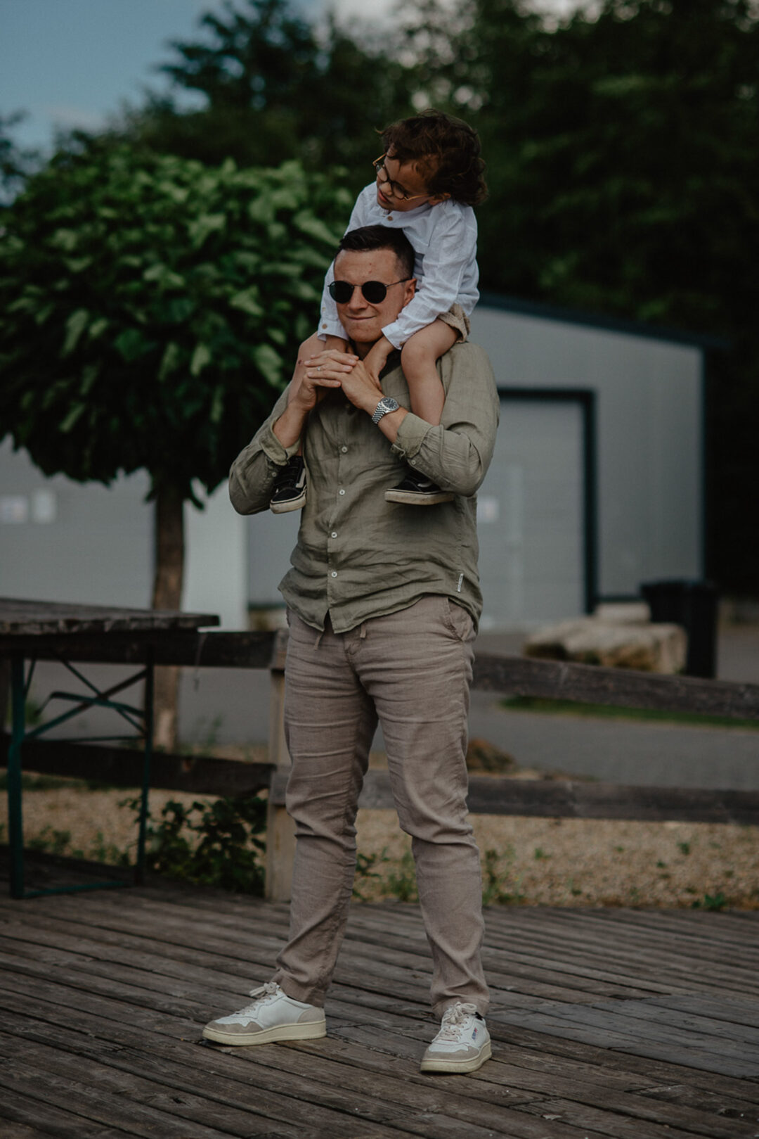 Kind sitzt auf Schultern eines Gasts