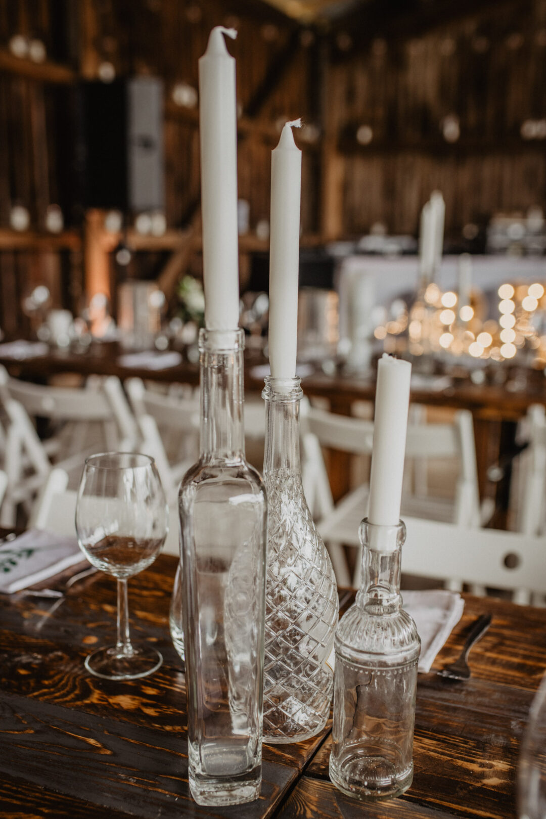 Kerzen in alten Glasflaschen auf Hochzeitstisch