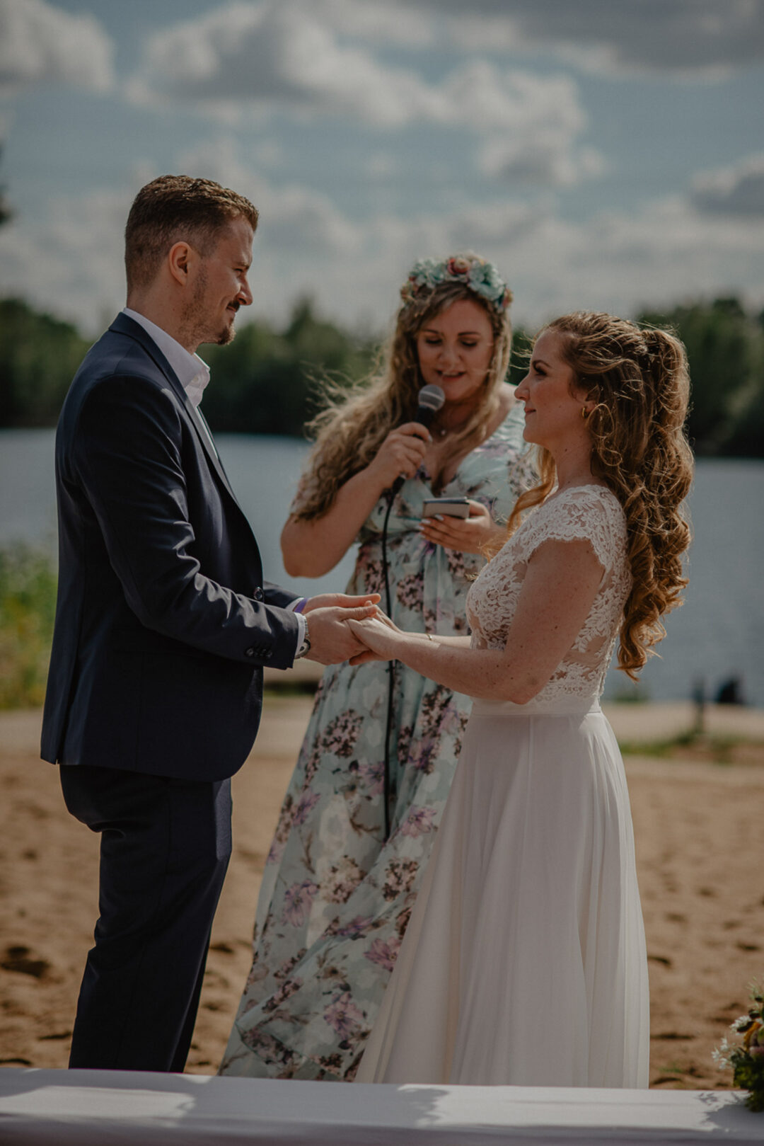 Brautpaar steht am Strand vor Rednerin