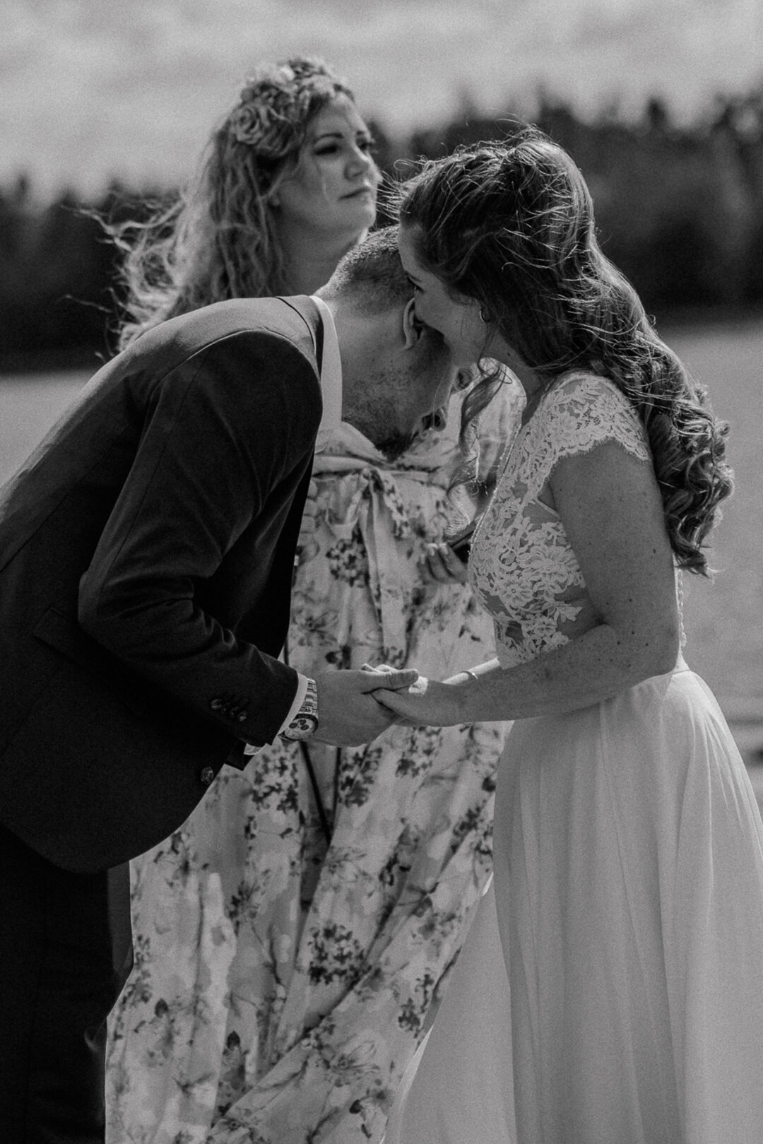 Bräutigam küsst Brauthand während Trauung