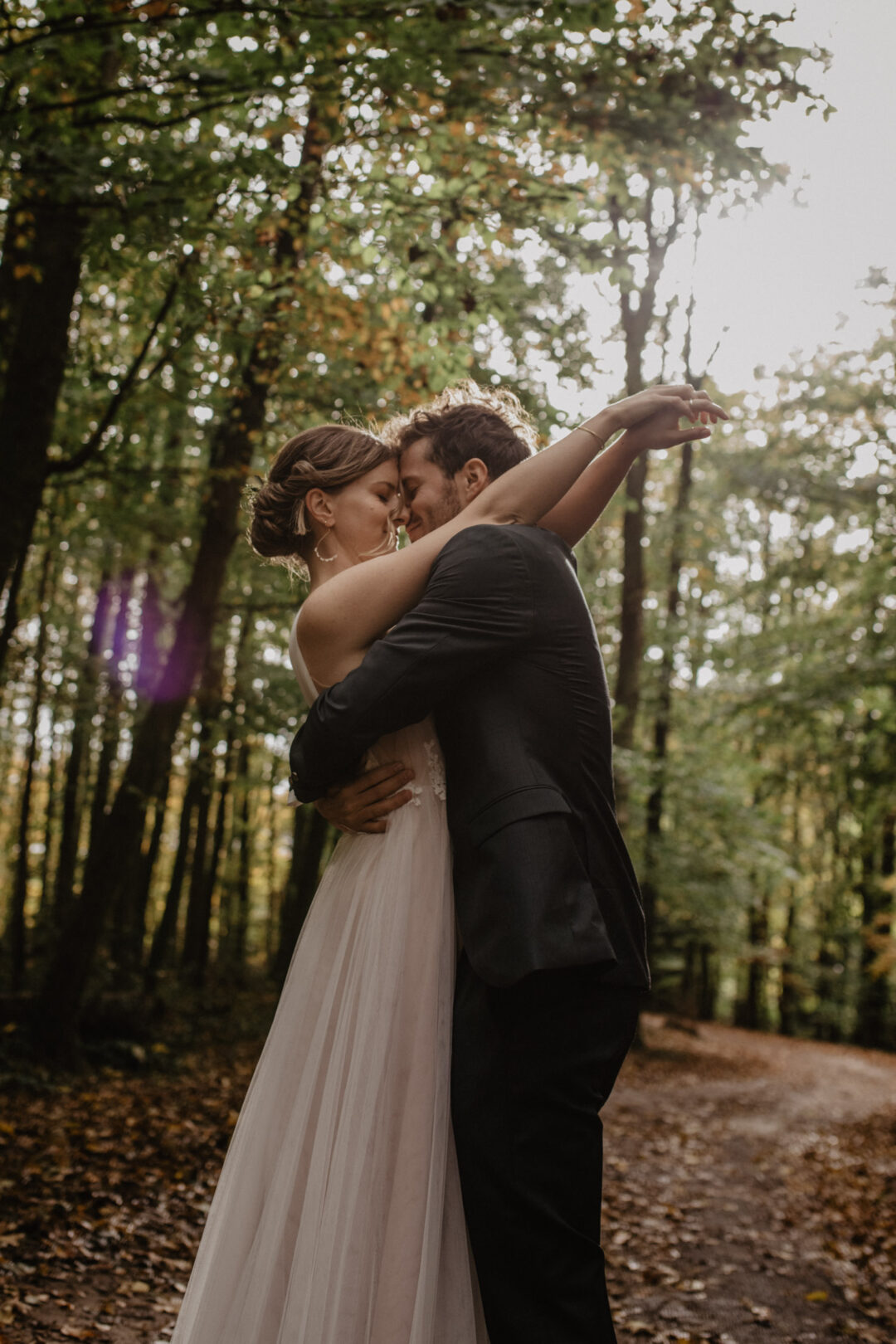 Braut und Bräutigam umarmen sich im Wald