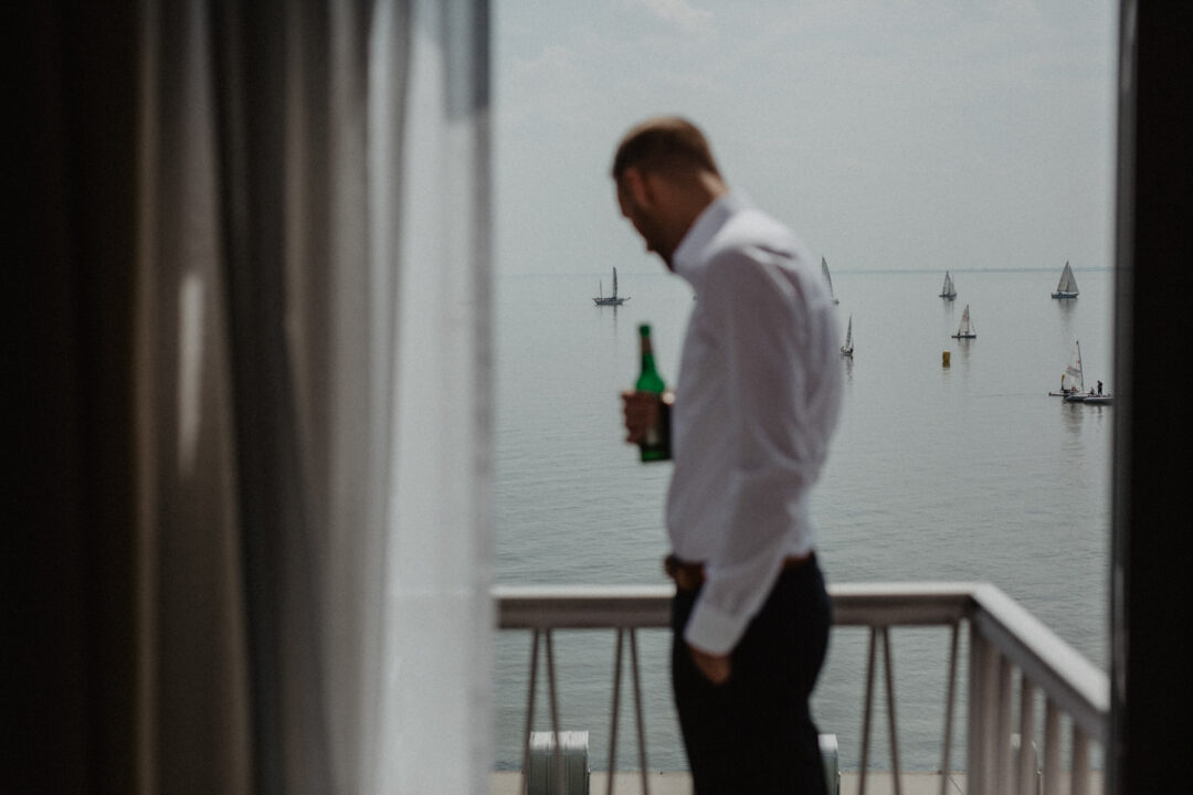 Bräutigam schaut nachdenklich aus dem Fenster