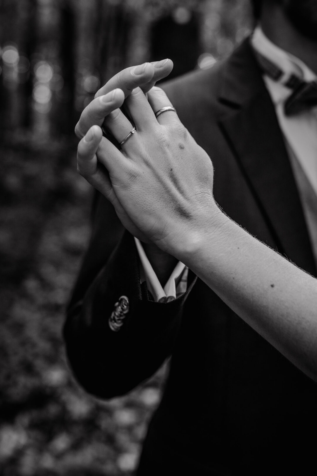 Eheringe an den Händen im Detail schwarzweiß fotografiert