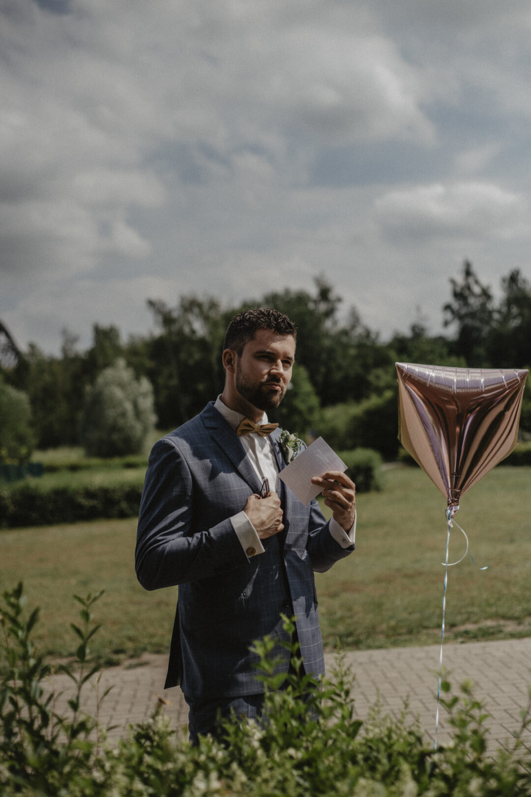 Bräutigam mit Anzug, Notiz und Ballon vor der Trauung