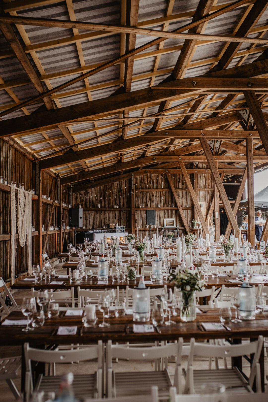 Blick in dekorierte Hochzeitsscheune mit Tischen