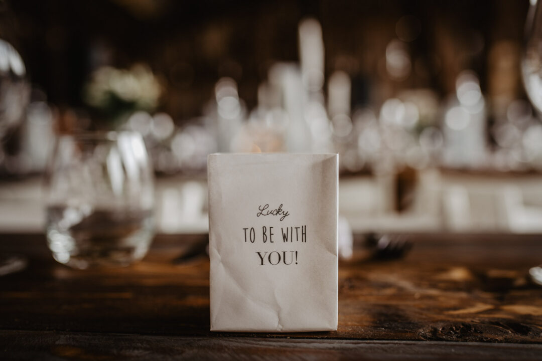 Papiergeschenk mit Aufschrift auf Hochzeitstisch