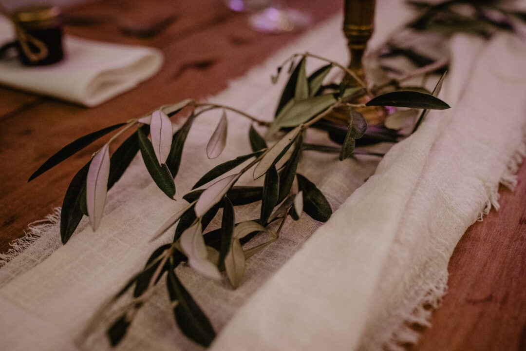 Natürliche Hochzeitsdeko mit Olivenzweigen auf Tischen
