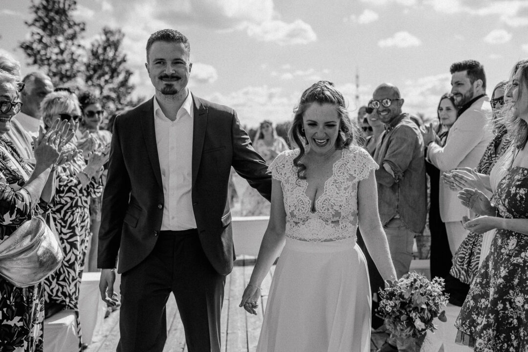 Fröhliches Brautpaar verlässt Trauung