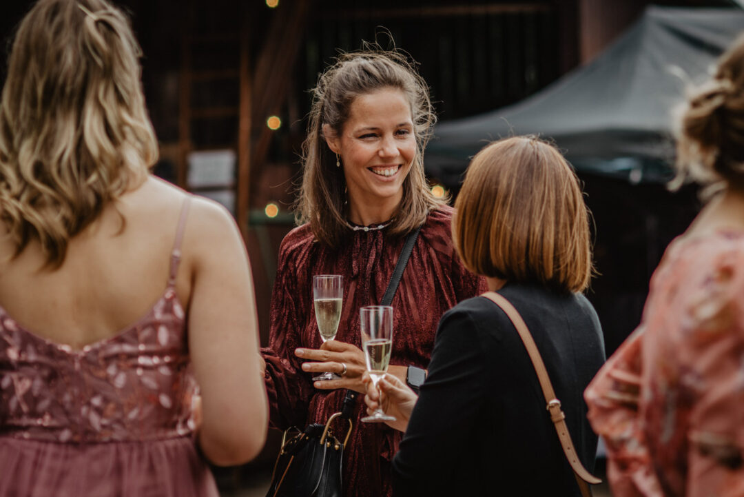 Hochzeitsgäste stoßen mit Sekt vor dem Foodtruck an