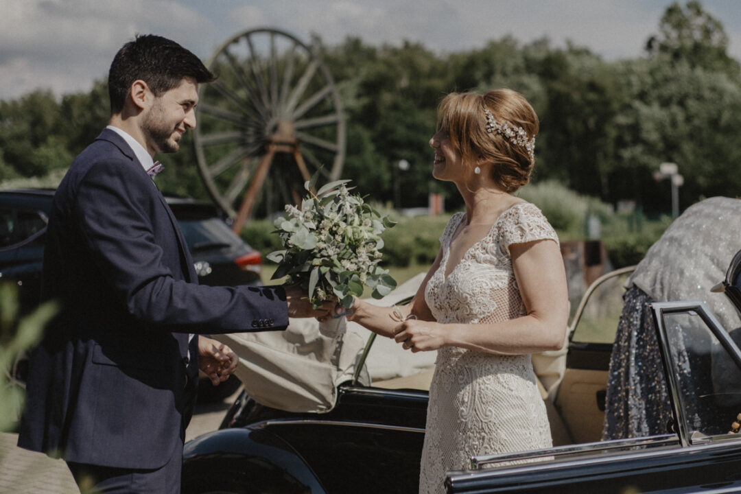 Bräutigam reicht Braut den Brautstrauß – Ankunft am Gasthaus Stromberg