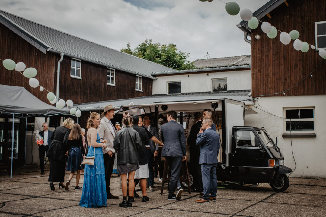 Gruppe feiert an mobiler Ape-Bar beim Hochzeitsfest