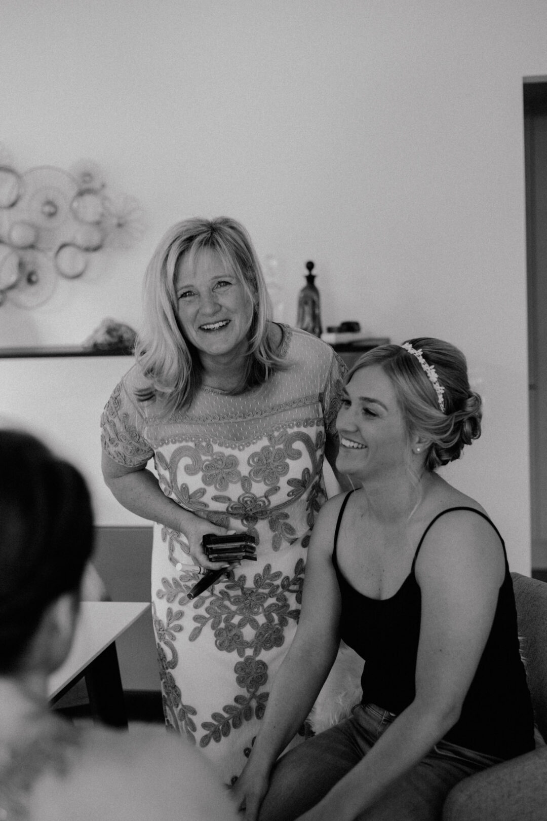 Braut und Mutter lachen gemeinsam in Schwarz-Weiß