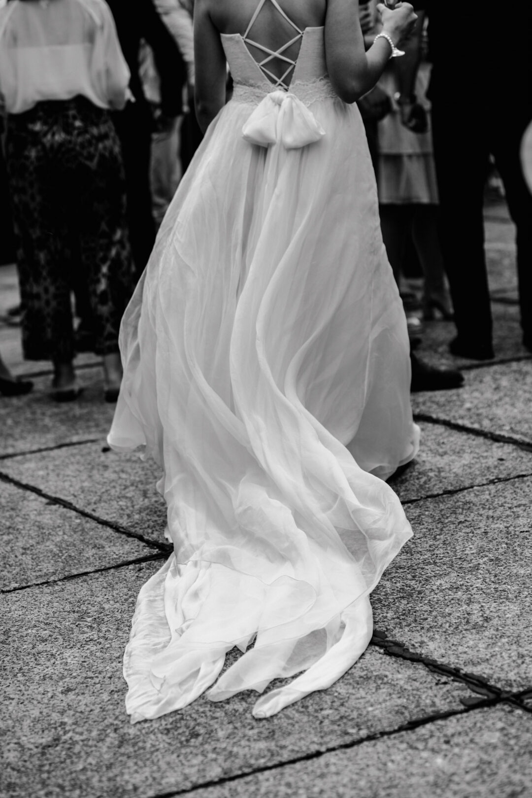 Schleppe eines fließenden Brautkleids auf Steinboden