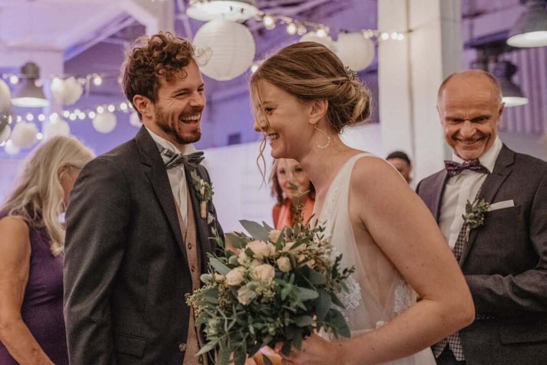 Braut und Bräutigam lachen während der Zeremonie