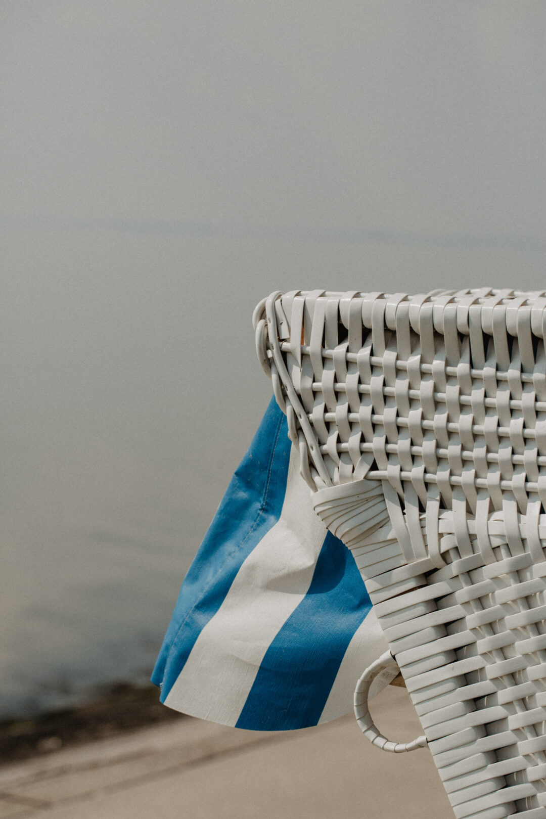 Nahaufnahme Strandkorb mit blau-weißer Markise