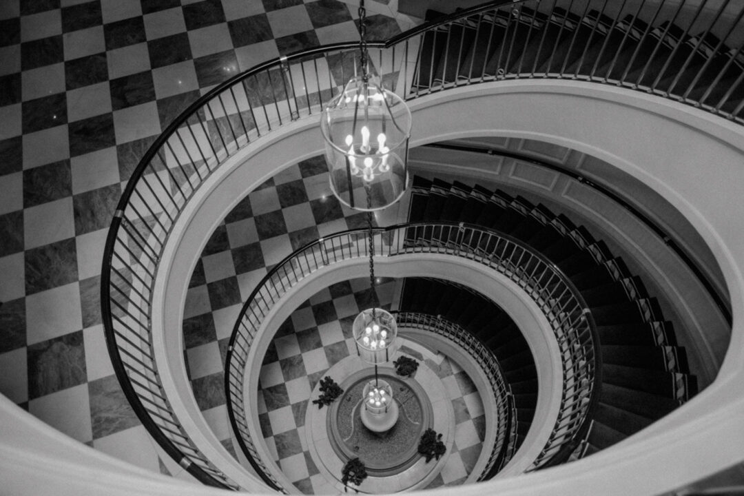 Spiralförmiges Treppenhaus mit Leuchtern von oben