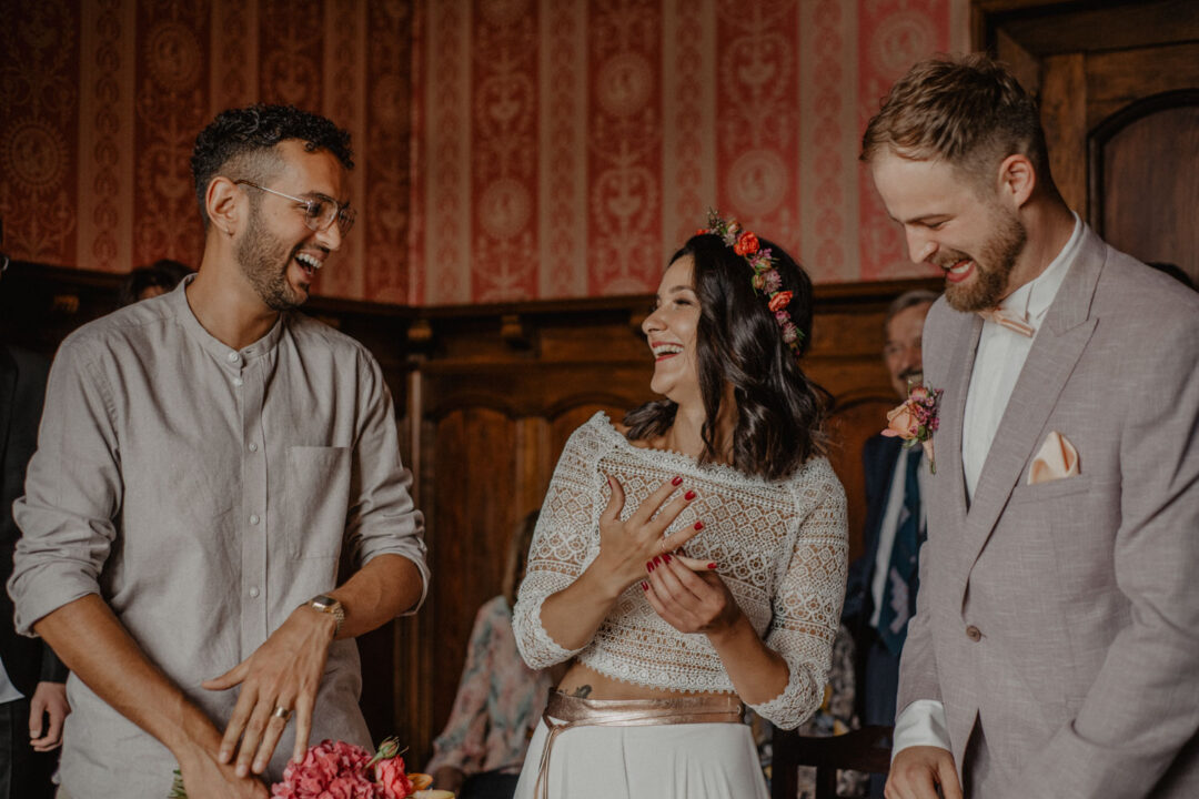 Lachender Gast mit Brautstrauß im Standesamt