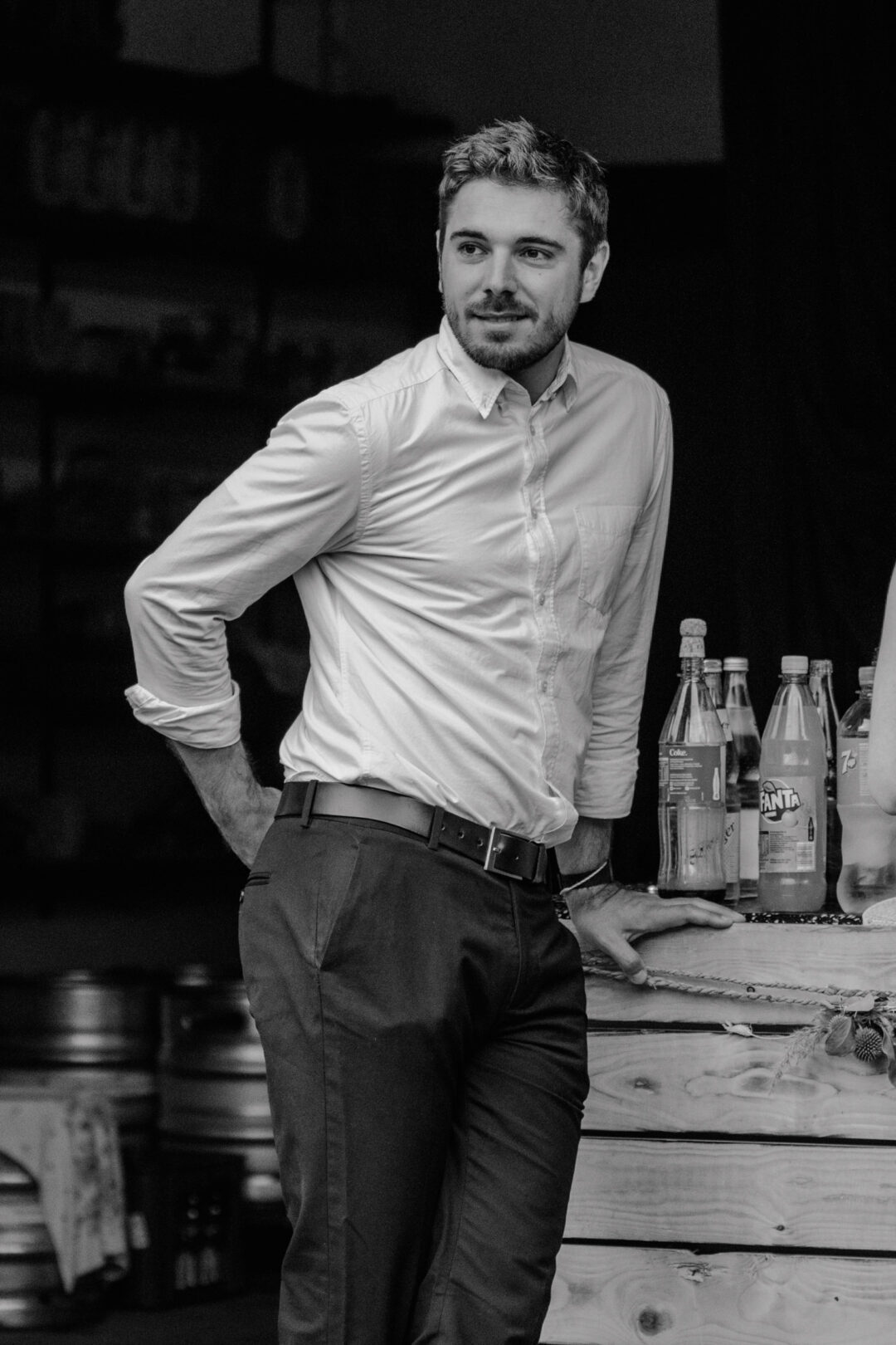 Mann in weißem Hemd lehnt lässig an Theke