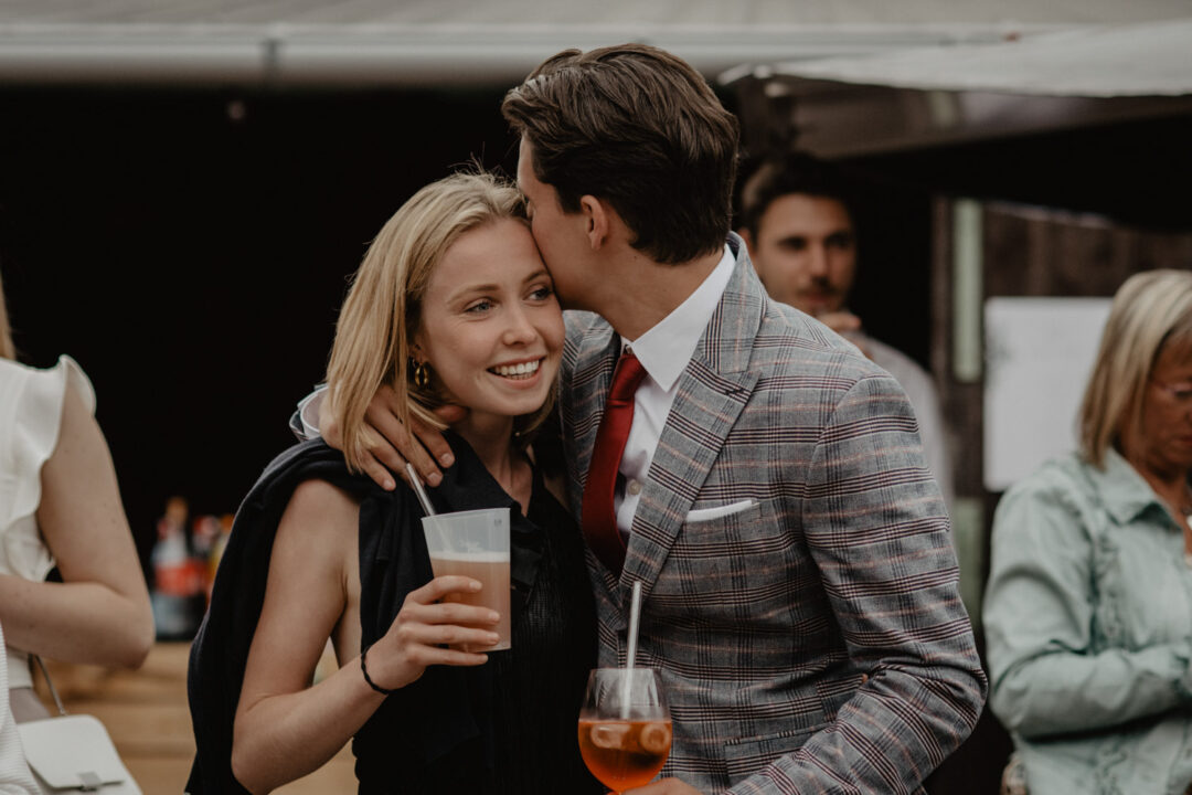 Verliebtes Paar mit Drinks bei Hochzeit im Freien