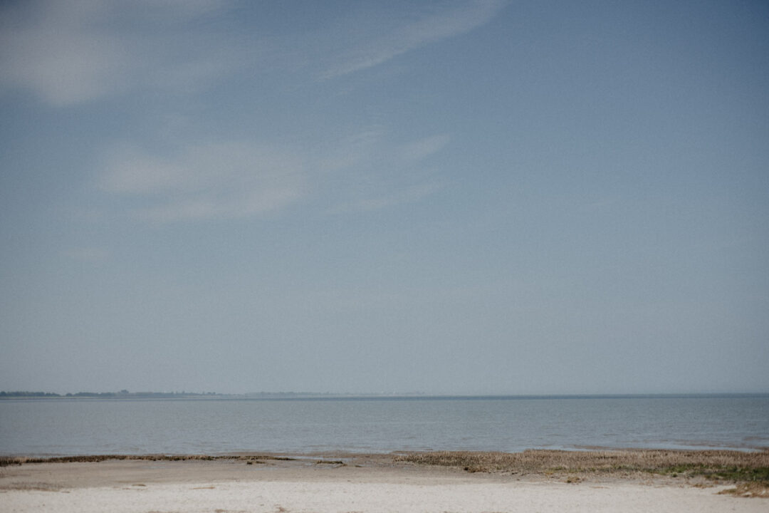Blick aufs ruhige Meer und den leeren Strand