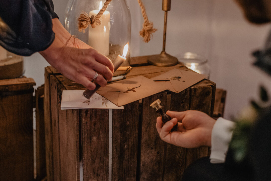 Wachssiegel wird auf Brief bei Hochzeit aufgetragen