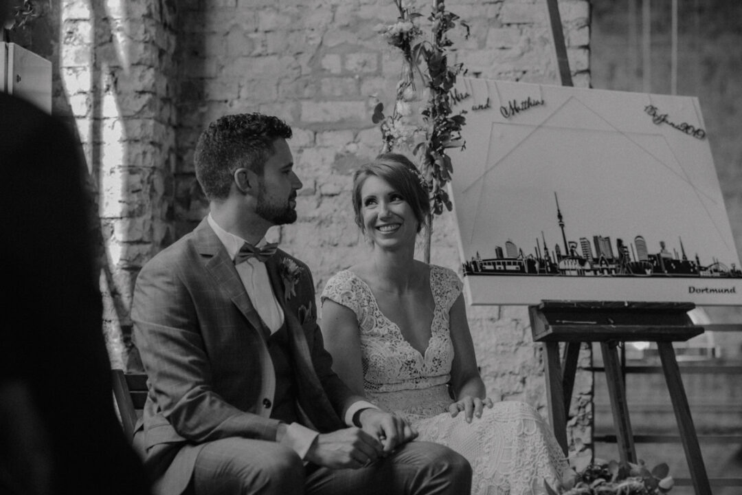 Schwarz-Weiß-Aufnahme eines innigen Moments zwischen Braut und Bräutigam