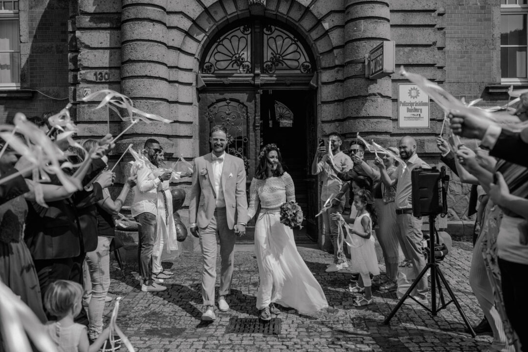 Brautpaar verlässt das Standesamt durch Spalier