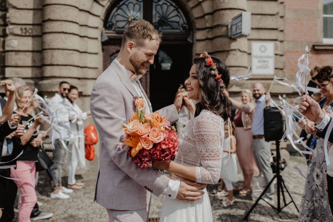 Brautpaar gratuliert sich lächelnd nach der Trauung