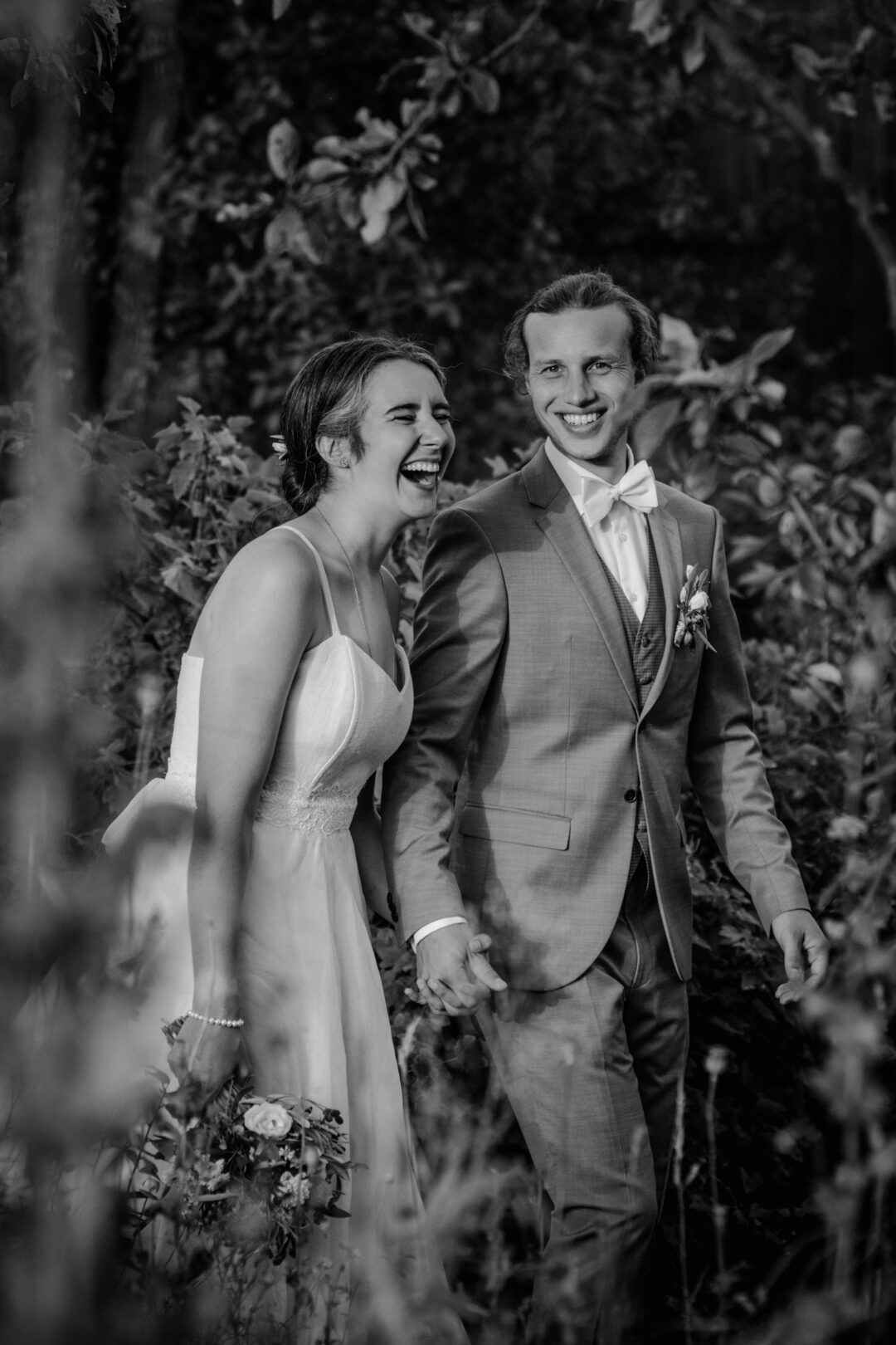 Brautpaar lacht gemeinsam im Hochzeitsgarten