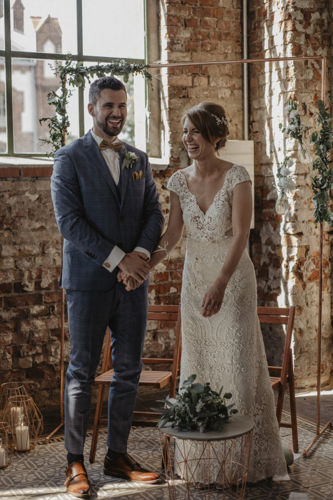 Brautpaar lacht bei der Trauung in der Maschienenhalle Waltrop