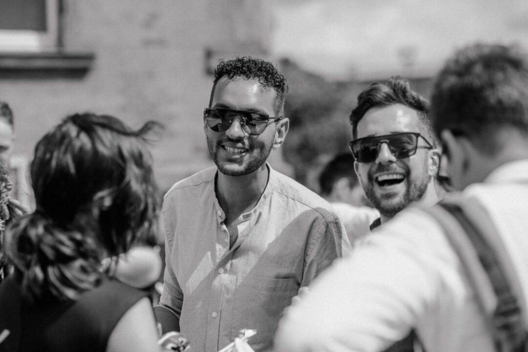 Freunde lachen bei der Hochzeit draußen