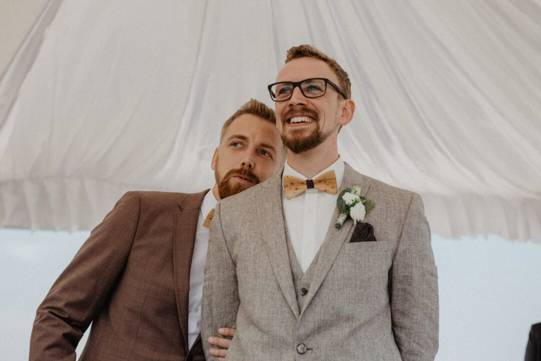 Bräutigam wartet lächelnd vor dem Trauzelt