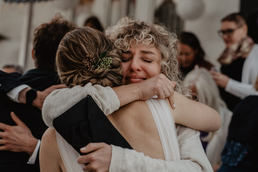 Innige Umarmung mit Freudentränen nach der Trauung
